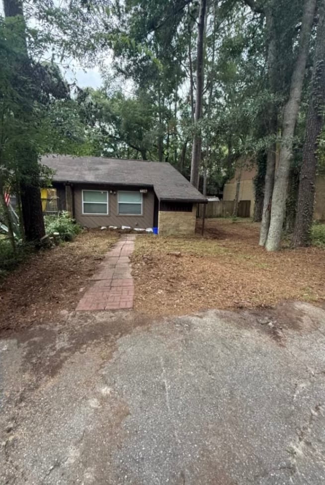 After — the same yard cleared to bare ground, with the brick walk uncovered end to end.
